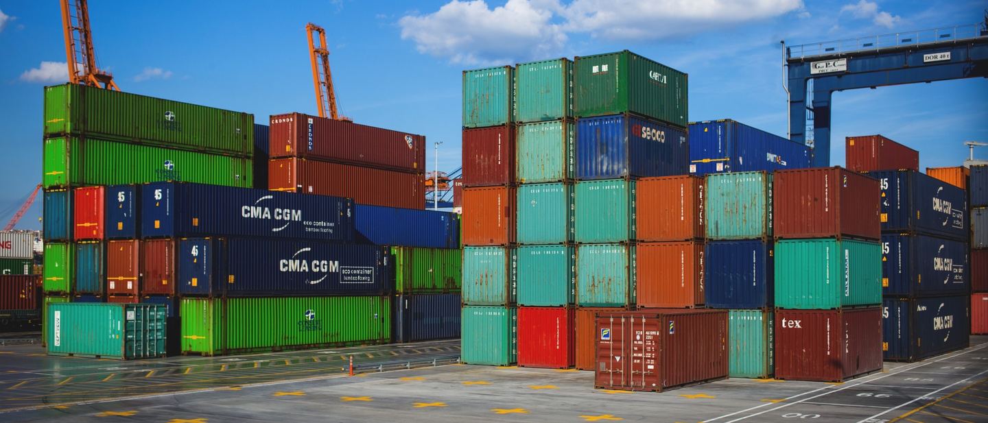 Stacked shipping containers arranged in rows at a commercial port terminal