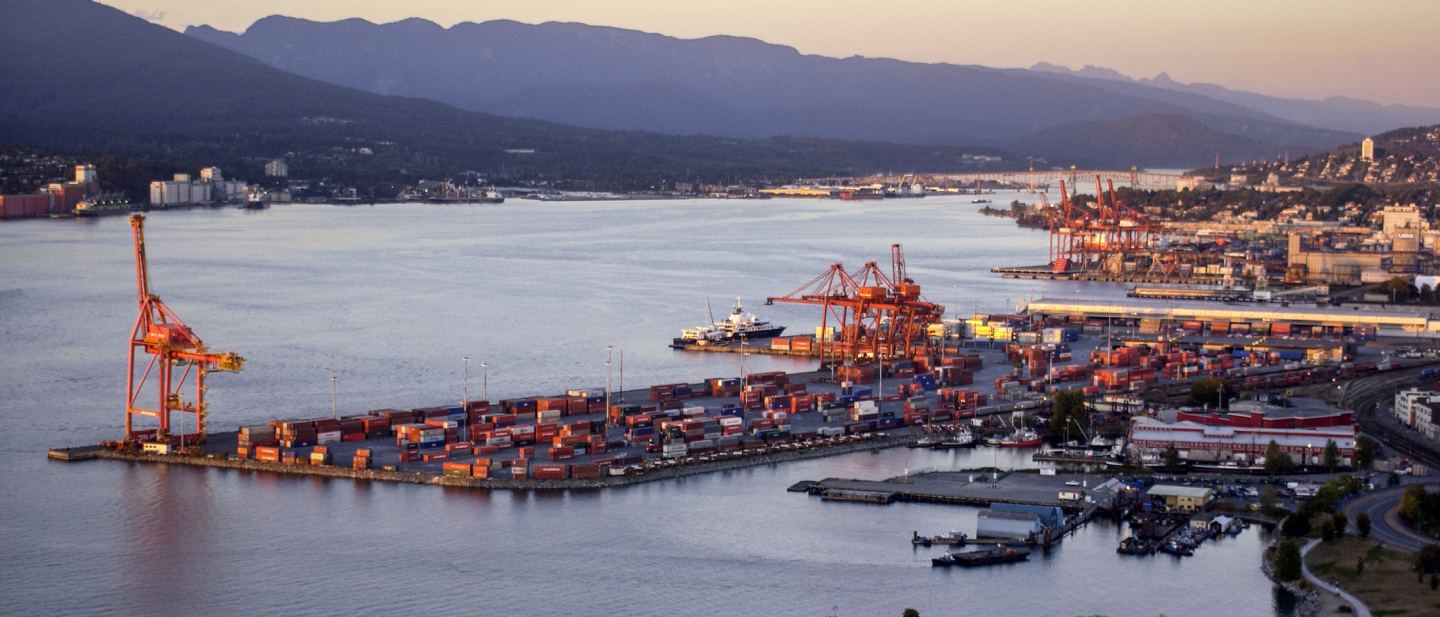 Container terminal and gantry cranes at a Pacific gateway port in British Columbia at dusk